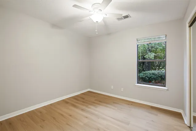an empty room with a window and wooden floor