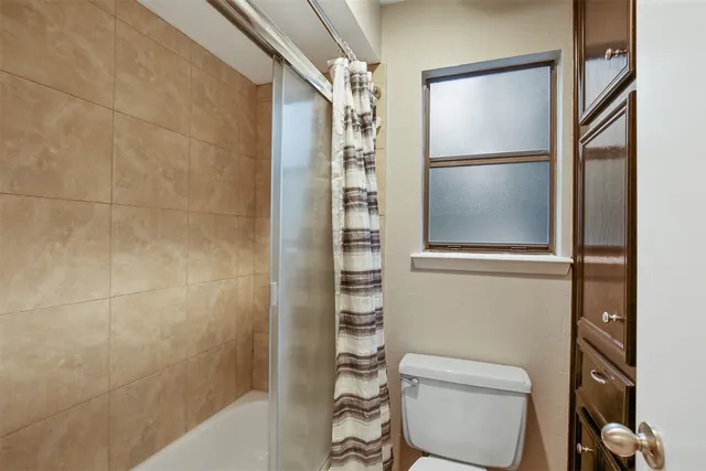 a bathroom with a toilet and a shower