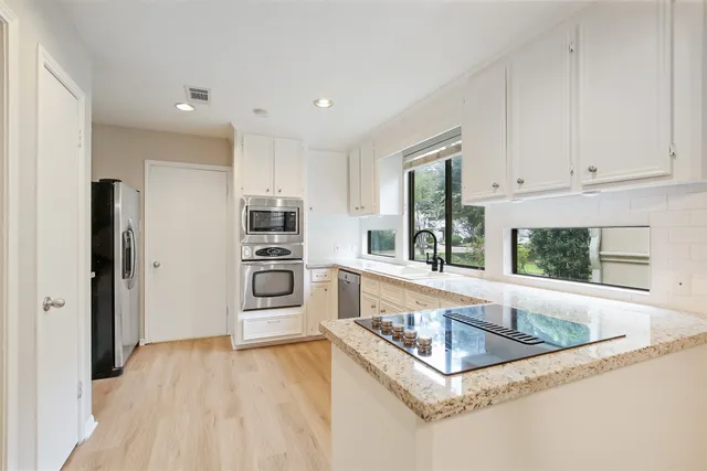 a kitchen with stainless steel appliances granite countertop a refrigerator and a sink