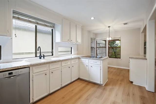 a kitchen with granite countertop white cabinets and white appliances