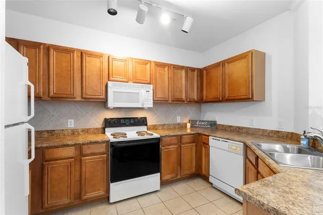 a kitchen with stainless steel appliances granite countertop sink stove top oven and cabinets