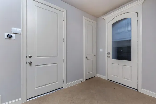 a view of an empty room with closet and a bathroom