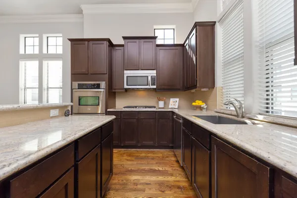 a kitchen with stainless steel appliances granite countertop a sink stove and cabinets