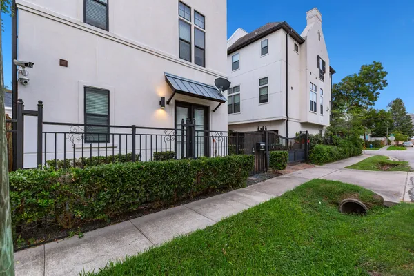 a view of a white house with a yard and plants