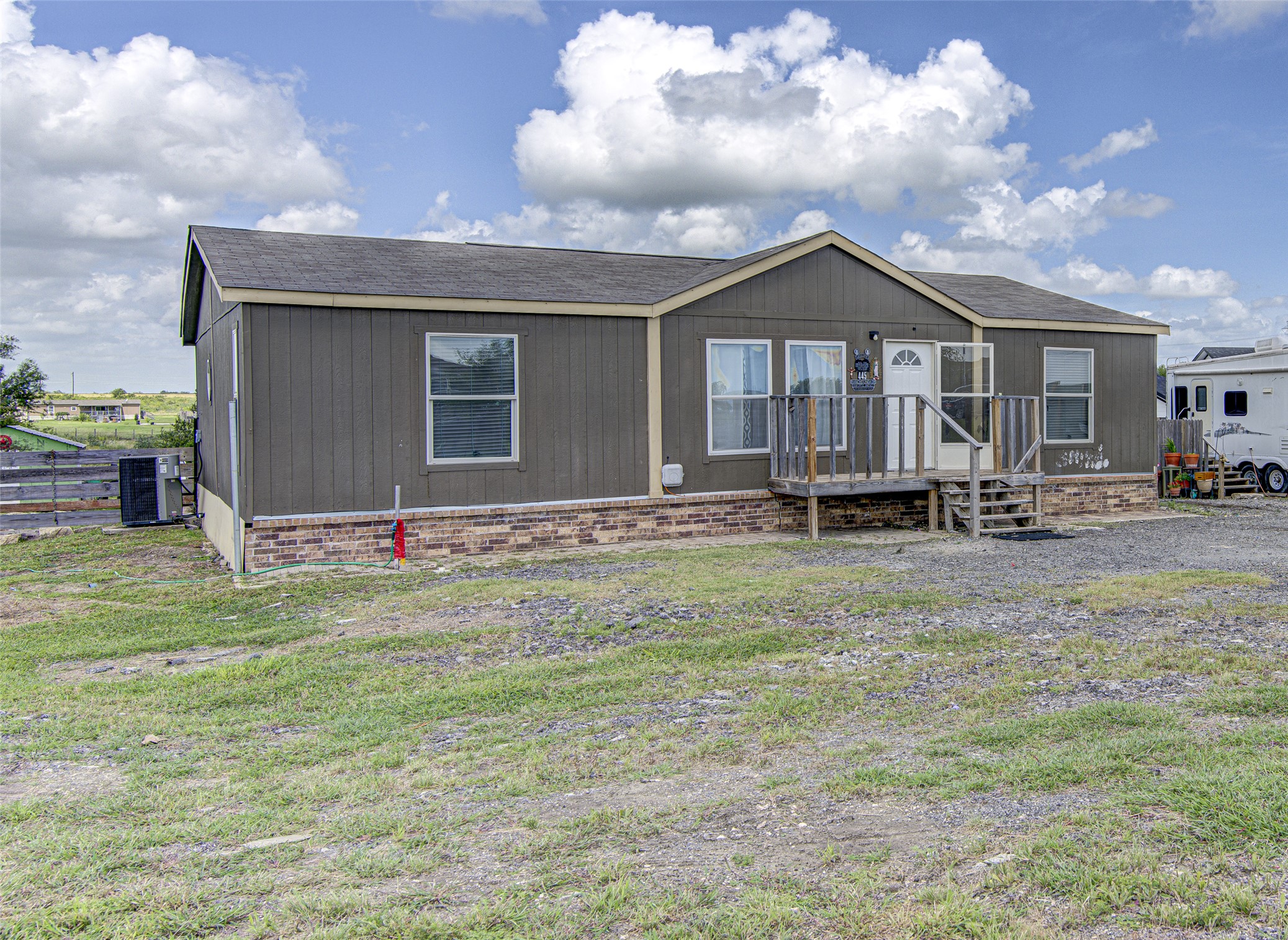 445 Rancho Linda Drive Lockhart, TX 78644 - Photo 2 of 26 A classic facade with a charming front deck and clear skies beckons you home.