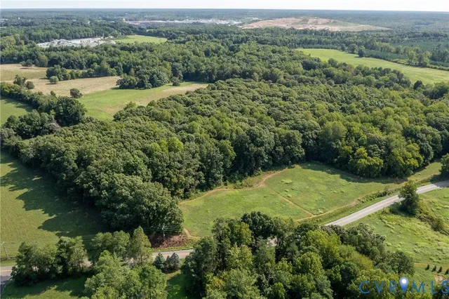 an aerial view of a residential houses with outdoor space and trees
