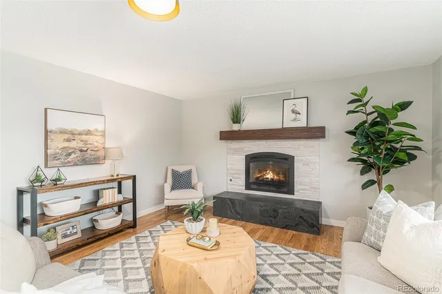a living room with furniture a fireplace and a potted plant