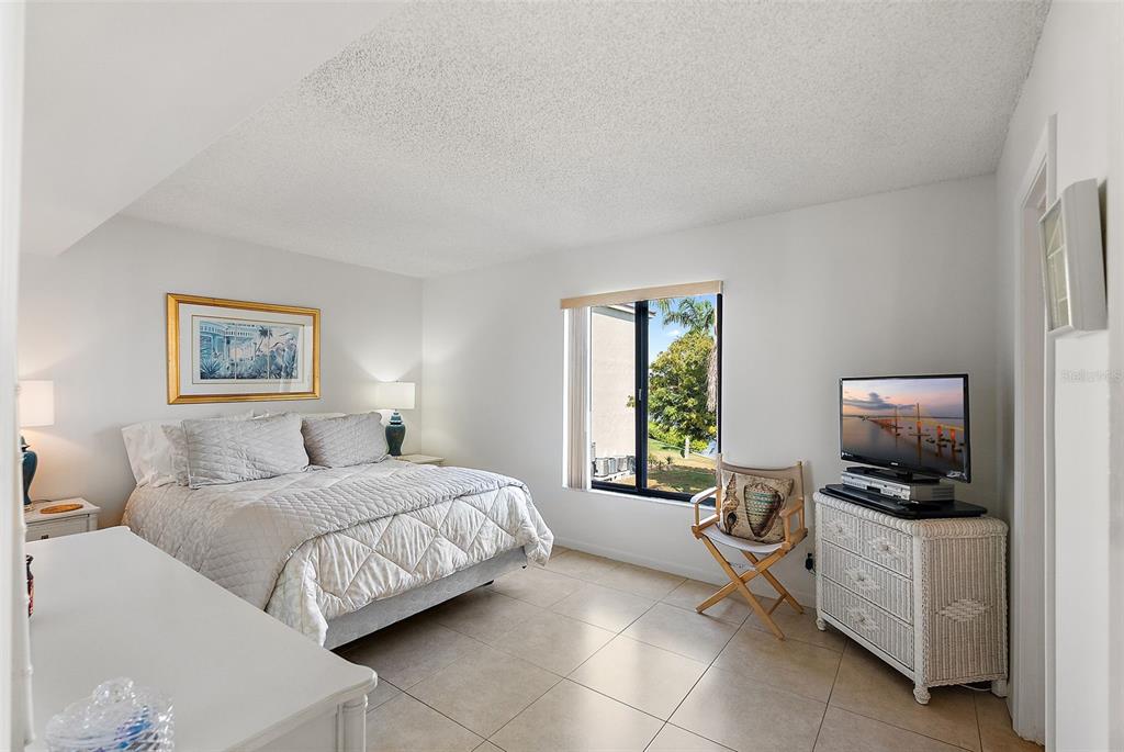 6322 Palma Del Mar Boulevard South, Unit 209 St. Petersburg, FL 33715 - Photo 13 of 42 a bedroom with a bed and a tv