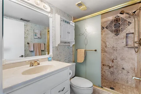 a bathroom with a sink toilet a shower and a mirror