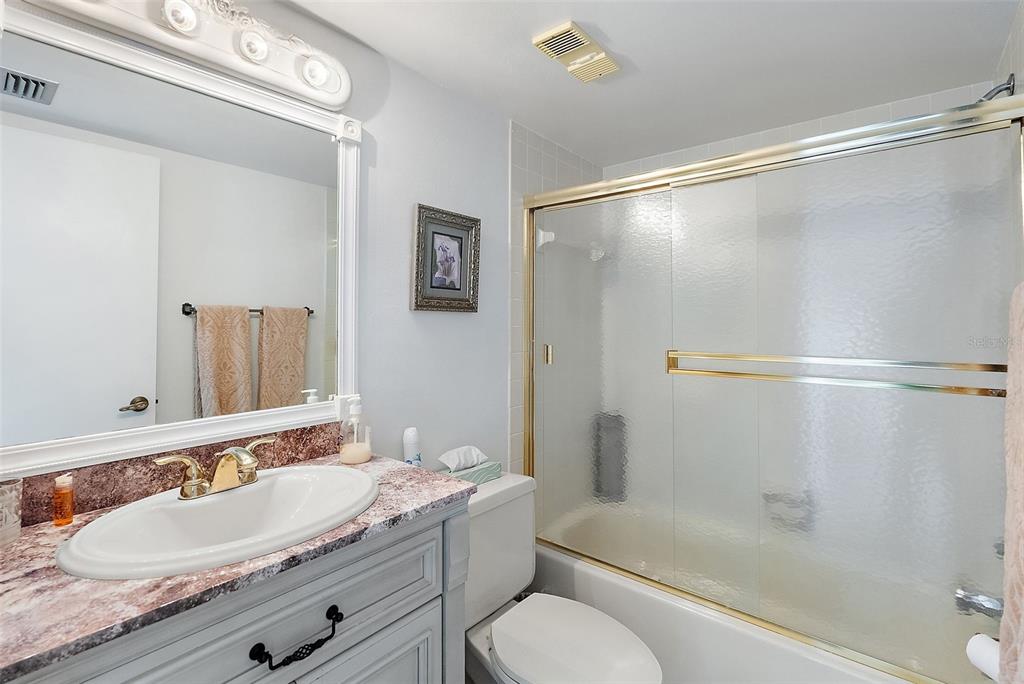 6322 Palma Del Mar Boulevard South, Unit 209 St. Petersburg, FL 33715 - Photo 16 of 42 a bathroom with a granite countertop sink toilet and shower