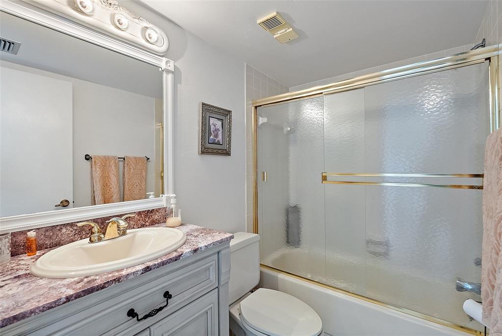 6322 Palma Del Mar Boulevard South, Unit 209 St. Petersburg, FL 33715 - Photo 20 of 42 a bathroom with a granite countertop sink toilet and shower