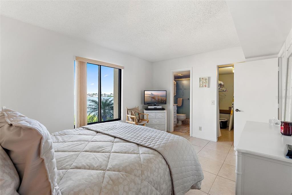6322 Palma Del Mar Boulevard South, Unit 209 St. Petersburg, FL 33715 - Photo 26 of 42 a bedroom with a bed a television and a large window