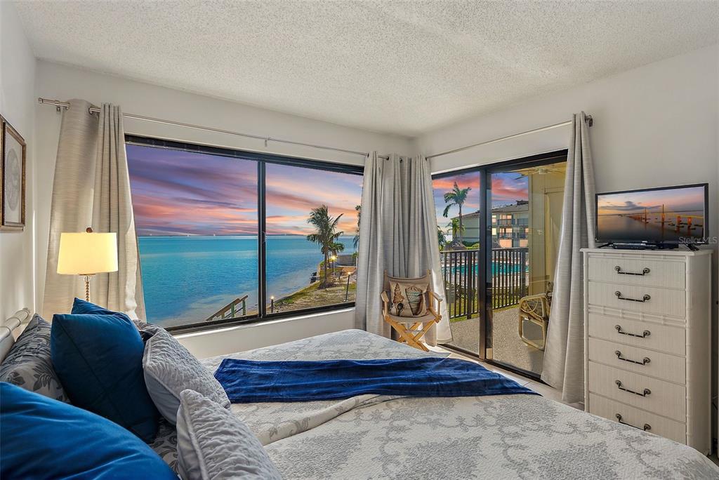 6322 Palma Del Mar Boulevard South, Unit 209 St. Petersburg, FL 33715 - Photo 42 of 42 a bedroom with a large bed and a flat tv screen next to a window