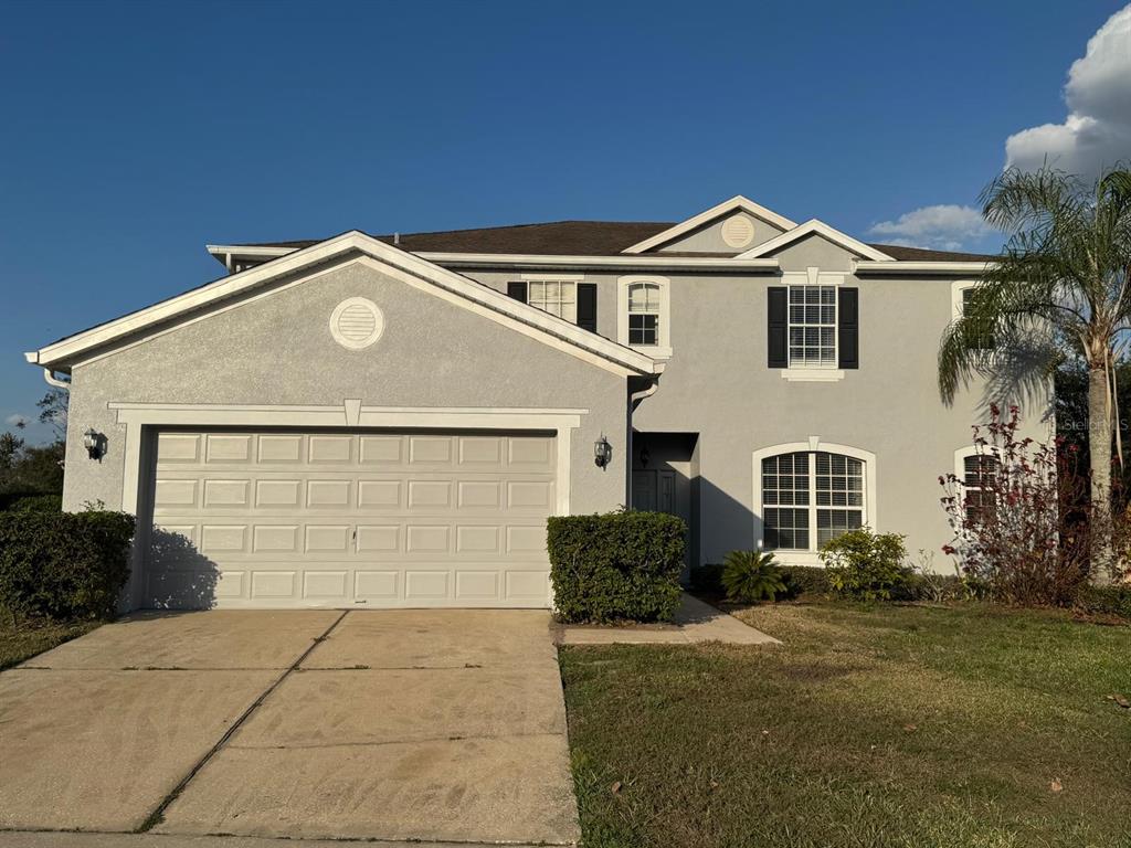 a front view of a house with a yard and garage