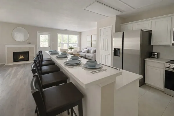 a kitchen with a table chairs refrigerator and cabinets