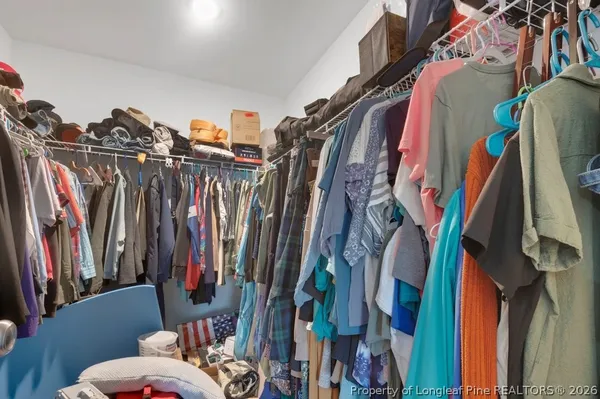 a view of walk in closet with clothes