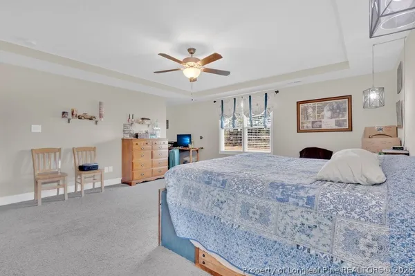 a bedroom with a large bed and a chandelier