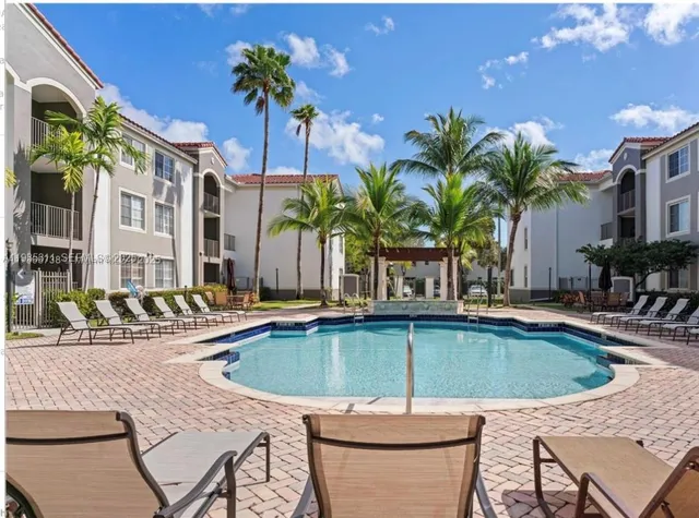 a view of a backyard with swimming pool and furniture