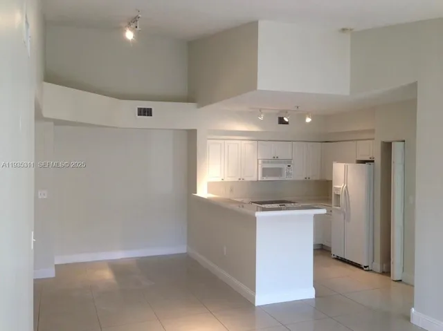 a kitchen with stainless steel appliances granite countertop a sink and a refrigerator