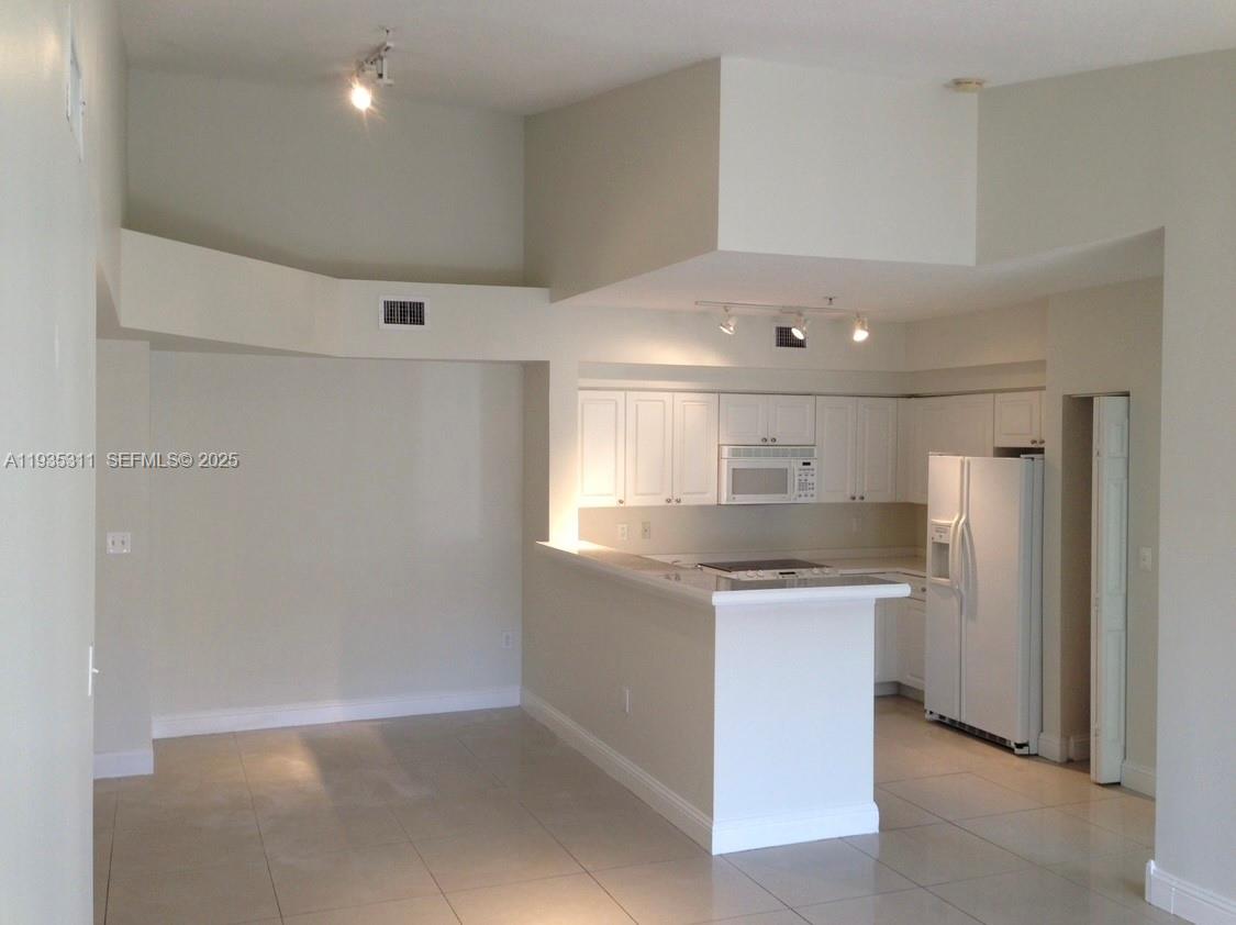 6851 Southwest 44th Street, Unit 308 Miami, FL 33155 - Photo 2 of 13 a kitchen with stainless steel appliances granite countertop a sink and a refrigerator