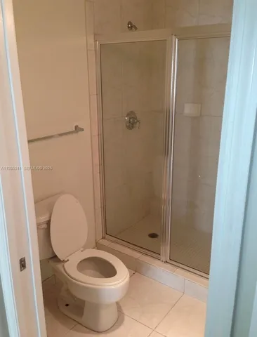 a bathroom with a granite countertop toilet and a shower