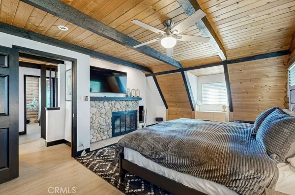 a bedroom with a bed a fireplace and a large window