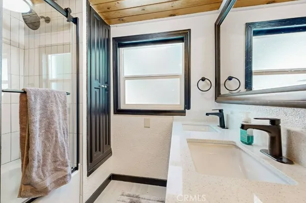 a bathroom with a sink and glass door shower