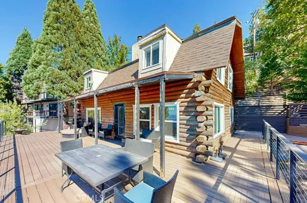 a roof deck with table and chairs a barbeque with potted plants and a barbeque