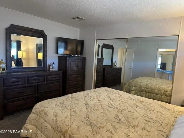 a bedroom with a bed and a large mirror on dresser