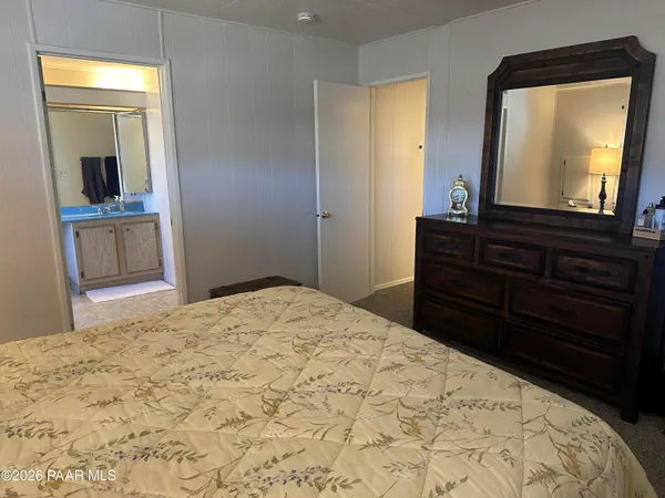 a bedroom with a bed and a mirror on dresser
