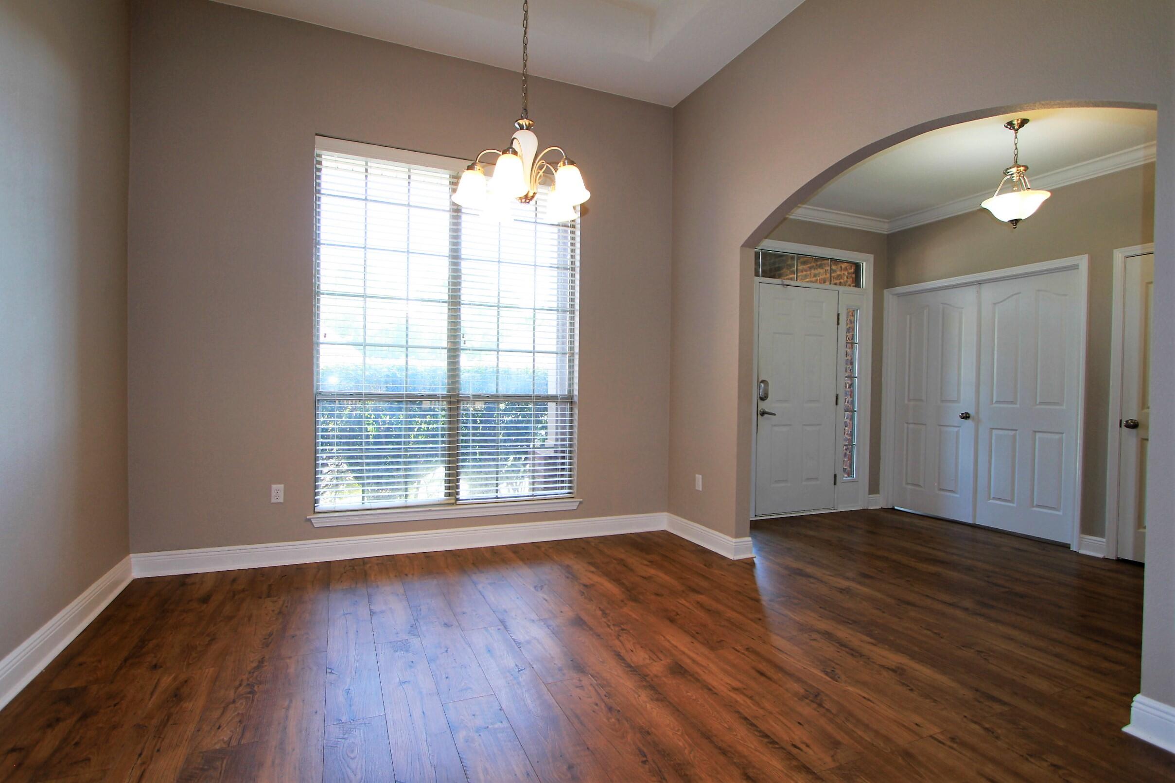 639 Red Fern Road Crestview, FL 32536 - Photo 3 of 24 an empty room with wooden floor and windows