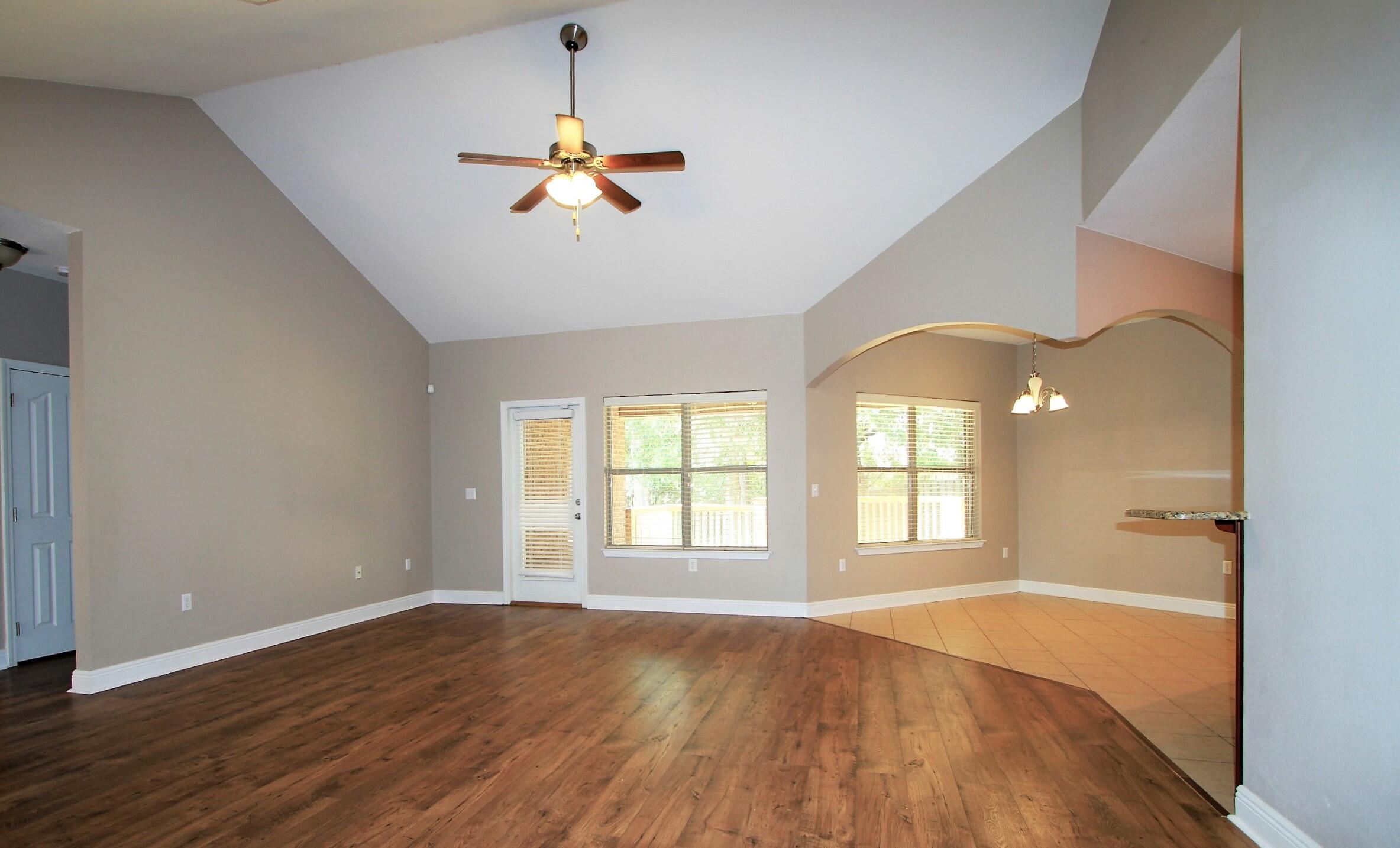 639 Red Fern Road Crestview, FL 32536 - Photo 5 of 24 an empty room with wooden floor chandelier fan and windows