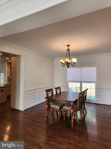 a view of a dining room with furniture wooden floor and chandelier
