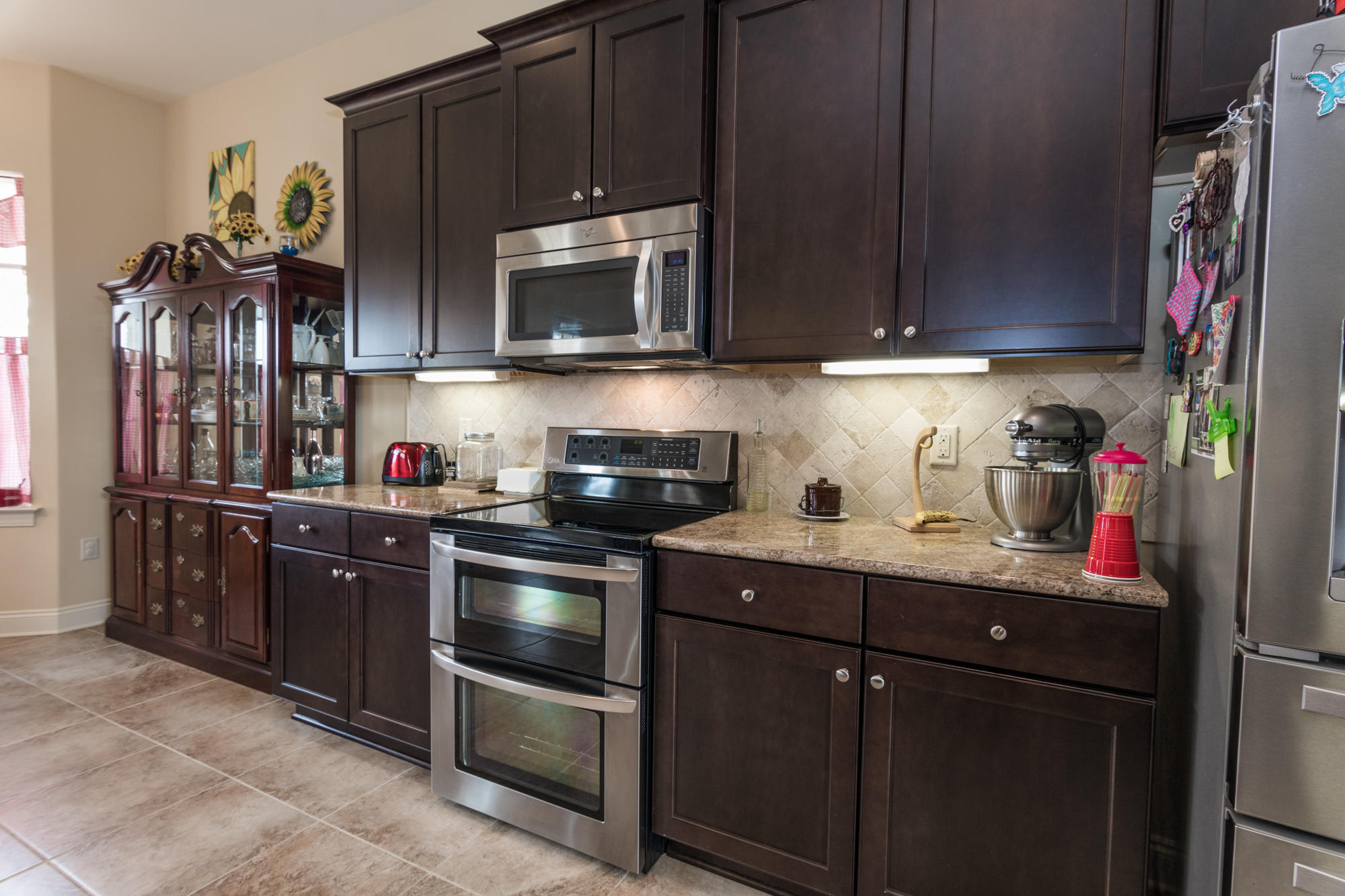 331 Brushed Dunes Circle Freeport, FL 32439 - Photo 11 of 60 a kitchen with stainless steel appliances granite countertop a sink stove and microwave