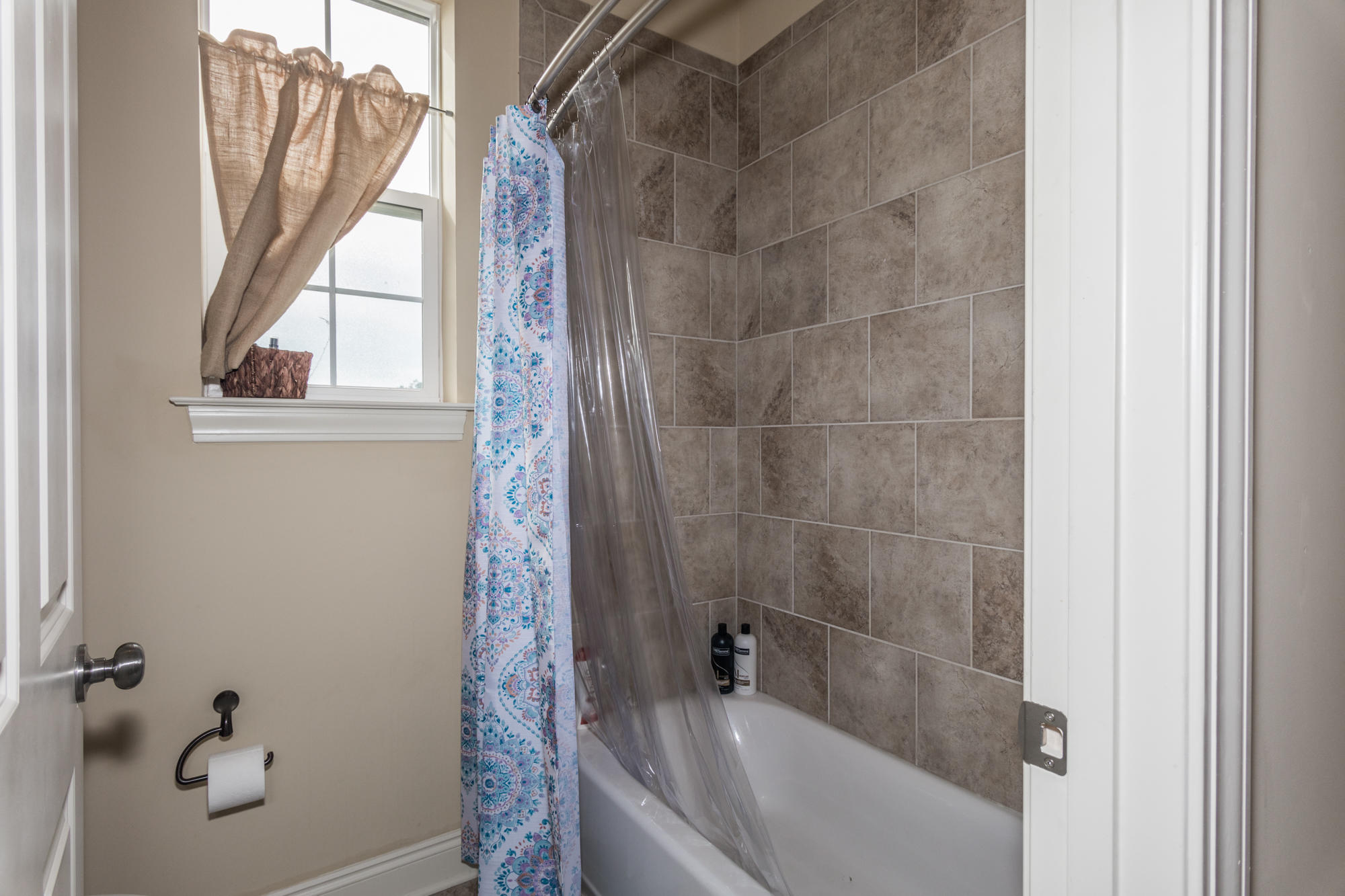 331 Brushed Dunes Circle Freeport, FL 32439 - Photo 32 of 60 a bathroom with a bathtub a window and a shower