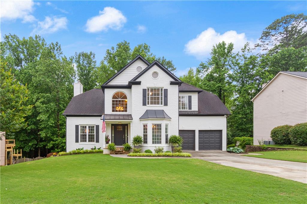 2150 Pendleton Place Northwest Suwanee, GA 30024 - Photo 1 of 1 a front view of a house with a garden and porch