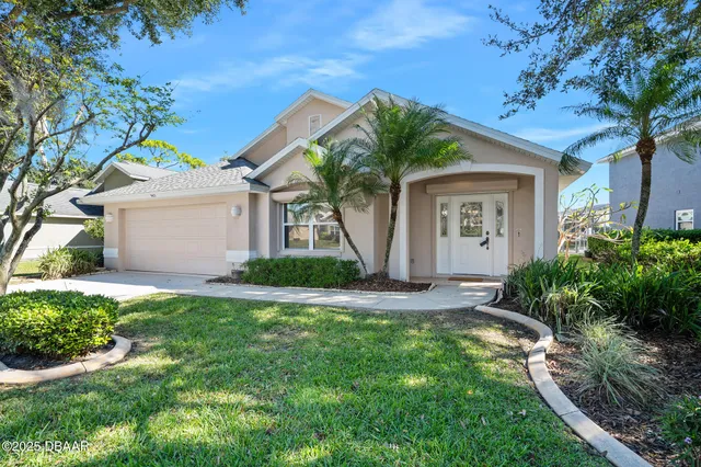a front view of a house with a yard and garage