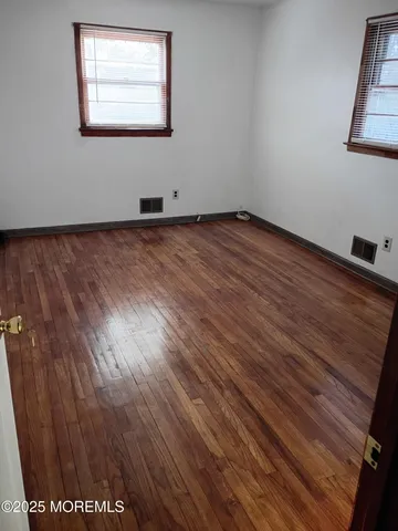 a view of wooden floor and window in a room