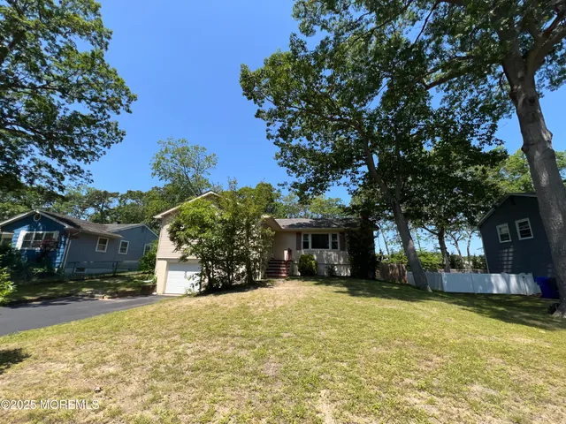 a view of house with yard and outdoor seating