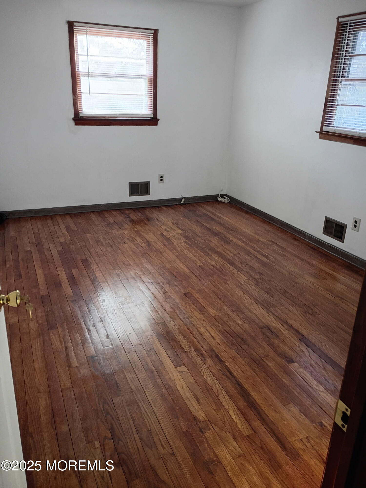 1595 Forge Pond Road Brick, NJ 08724 - Photo 9 of 35 an empty room with wooden floor and windows