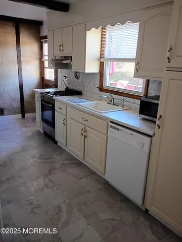a kitchen with a sink cabinets and stainless steel appliances