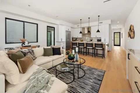 a living room with furniture kitchen view and a large window