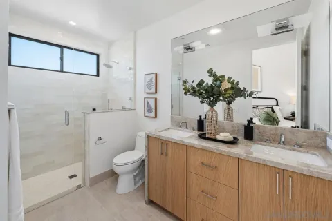 a bathroom with a granite countertop sink a toilet and shower