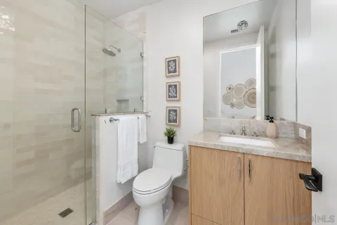 a bathroom with a granite countertop sink toilet and shower