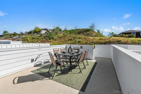 a view of a terrace with furniture and city view