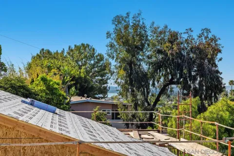 a view of a balcony with floor to ceiling windows and wooden fence