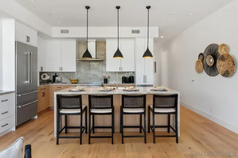 a kitchen with granite countertop a table chairs stove and refrigerator
