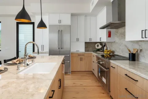 a kitchen with stainless steel appliances granite countertop a sink a stove and a wooden floors