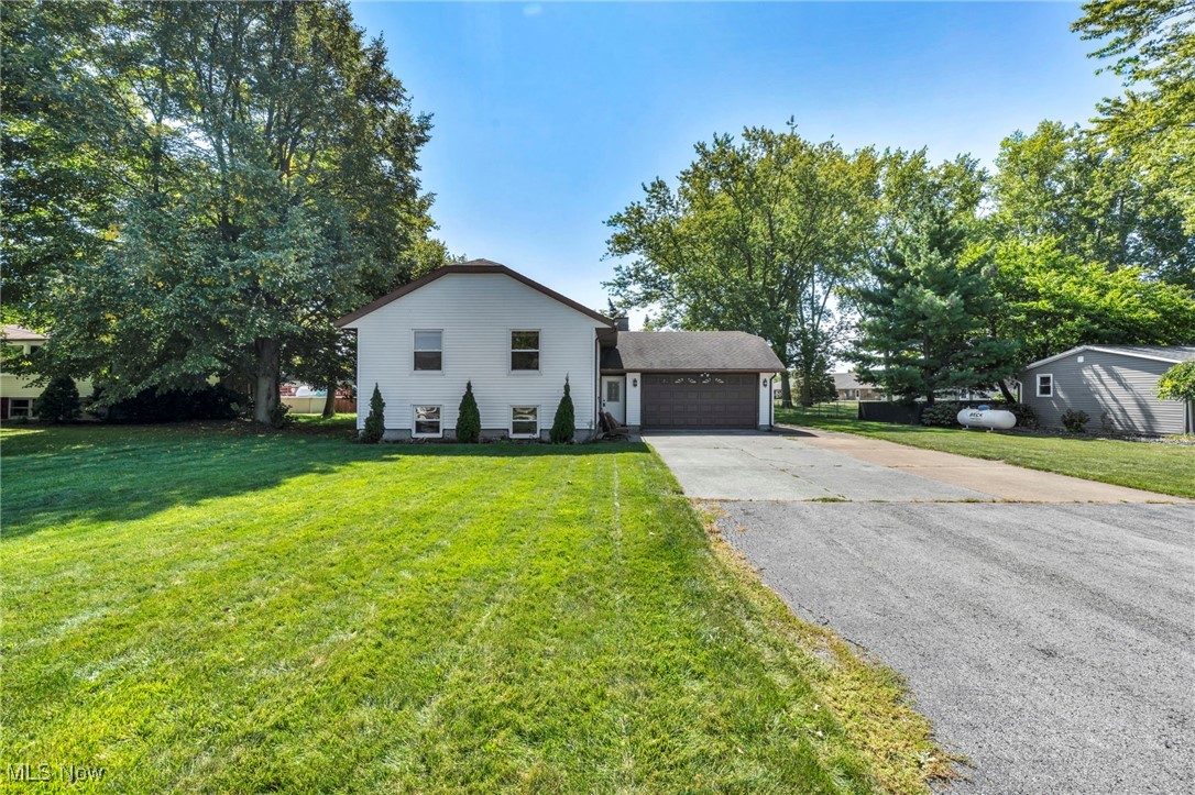 5704 McCartney Road Sandusky, OH 44870 - Photo 2 of 50 View of front of house with a front lawn, a garage, and driveway