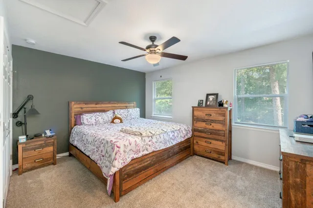 a bedroom with a bed and a chandelier fan